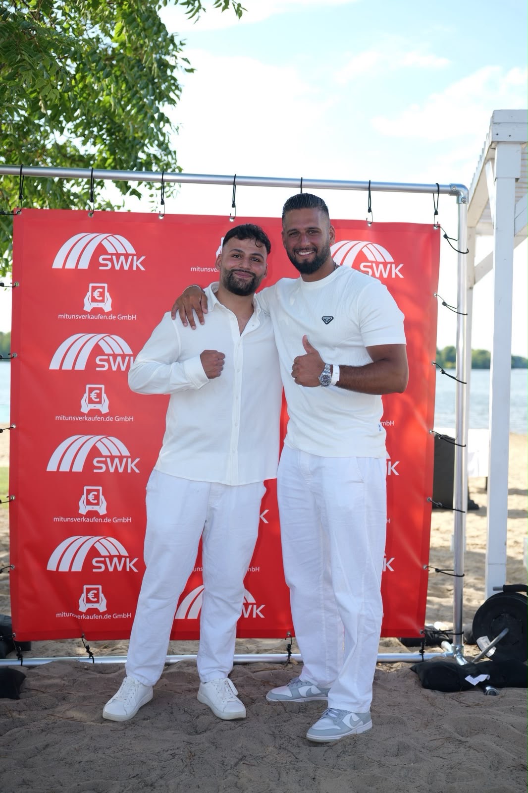 Zwei Vertriebspartner beim Sommer-Event vor der SWK-Wand